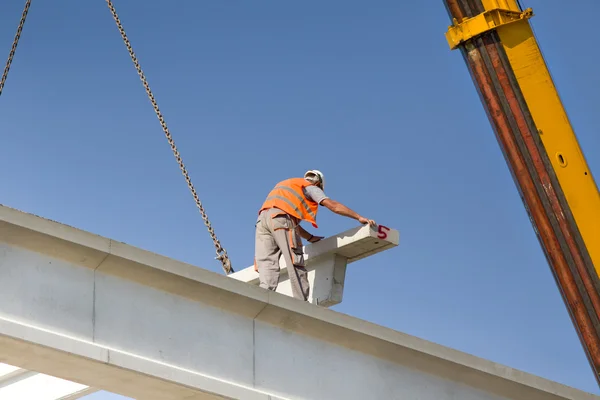 Height worker placing truss in skeleton