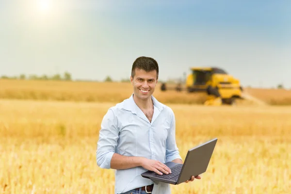 Businessman with laptop in field