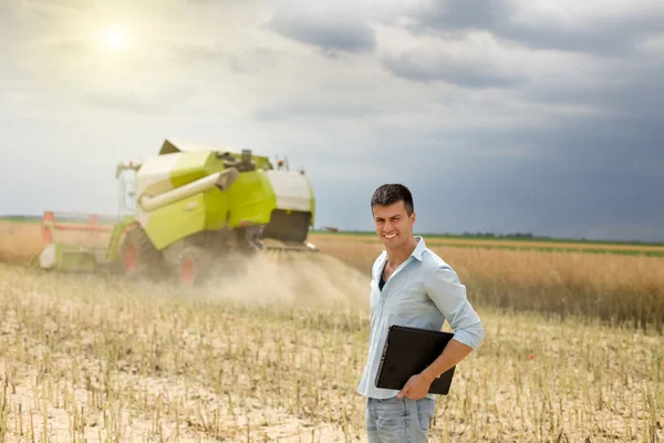 Businessman with laptop in field