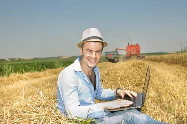 Man with laptop on haystack
