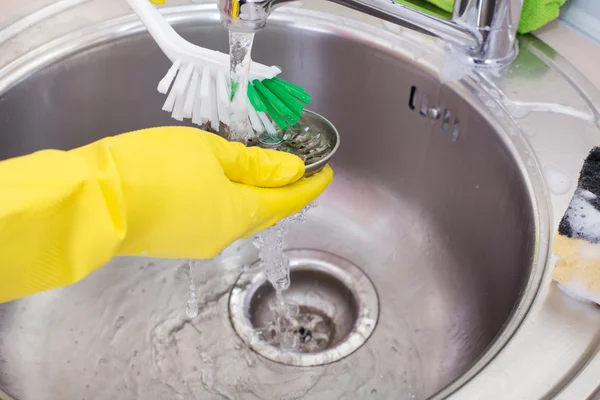 Woman cleaning kitchen sink