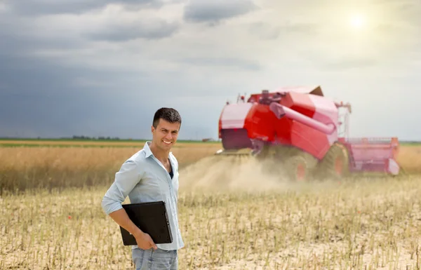 Businessman with laptop in field