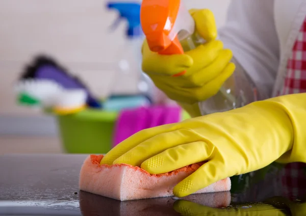 Woman cleaning with sponge and liquid detergent