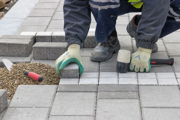 Construction worker setting sidewalk pavement