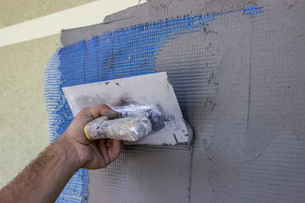 Spreading mortar on mesh of styrofoam insulation wall 2