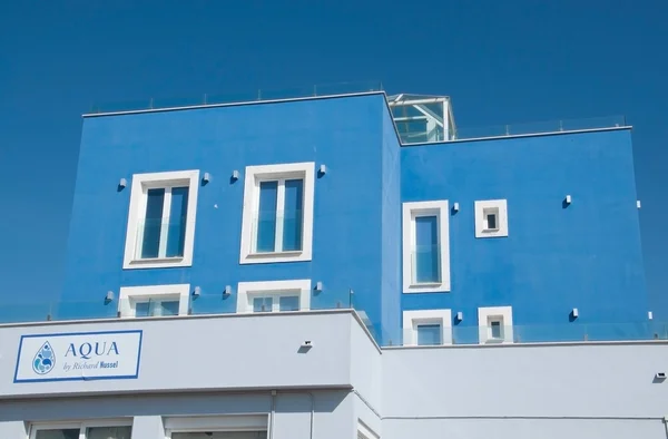 Modern sky blue building hosting the restaurant Aqua