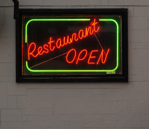 A red and green neon sign, saying restaurant open