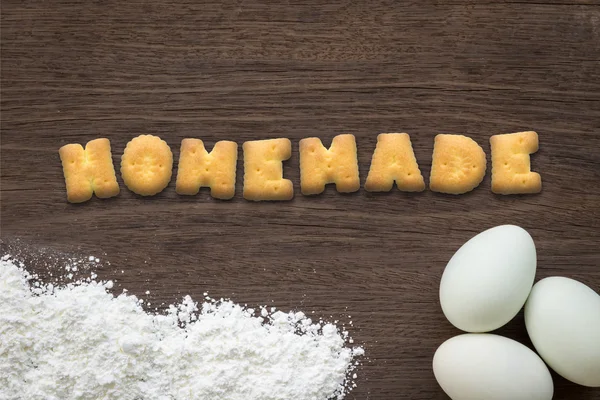 Alphabet cookies word HOMEMADE on cooking table background