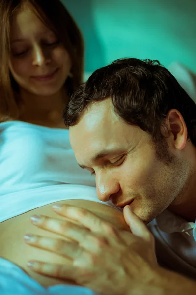 Image of happy future dad kiss the belly of his pregnant wife