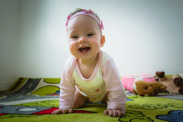 Adorable baby girl crawls on all fours floor at home. Smiling