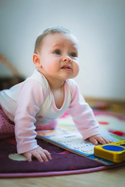 Adorable baby girl crawls on all fours floor at home