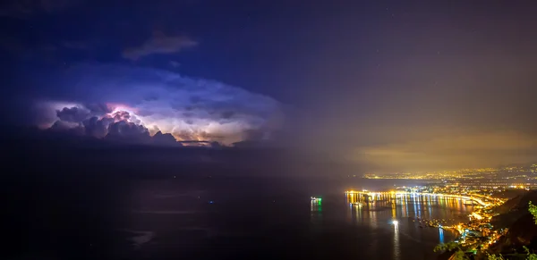 Storm Clouds and Illuminated Taormina Coastline