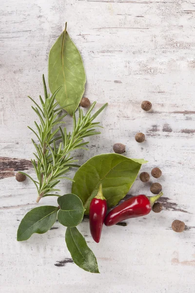 Bay leaves, spice and condiments wooden background.