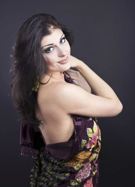 Attractive brunette in a bright attire on a black background. Fashion portrait. Portrait of a beautiful brunette. Bright embroidered handkerchief