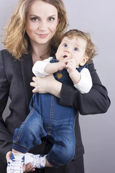 Beautiful blonde with her little son on hands. Happy business woman. Family life. Children. Young mother