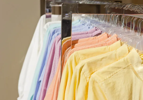 Bright colored shirts on hangers. Cotton shirts at the supermarket. Qualitative clothes