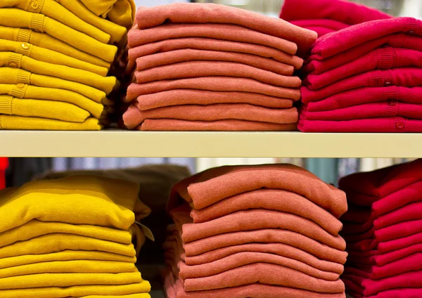 Colorful sweaters in a big supermarket. Beautifully stacked woolen things