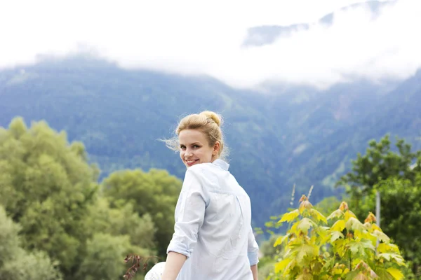 Beautiful young girl on the nature in the highlands. Young girl outdoors alone. Dreamy girl sitting near the country house