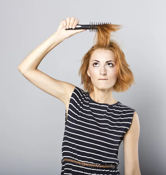 Skinny redhead girl brushing her hair.Woman hair style fashion portrait . isolated. close up female face.