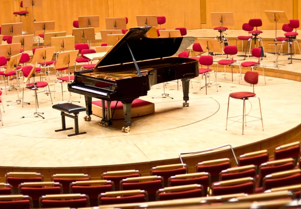 Large black grand piano on a bare stage. Musical instrument.