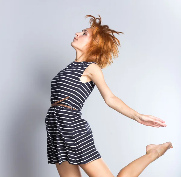 Slim red-haired girl in a jump. Portrait of beautiful girl in full growth. fashion portrait