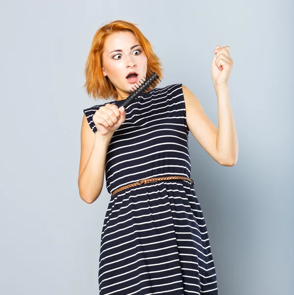 Red-haired girl with a round hairbrush. Hair. hair fall out