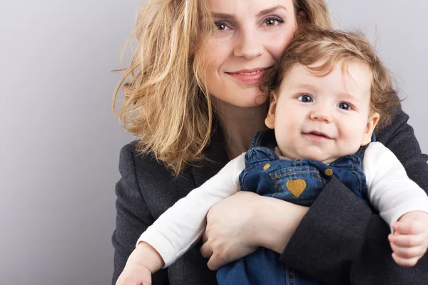 Young mother with a little boy in her arms. Portrait of mother and son. Beautiful blonde. pectoral baby. happy family