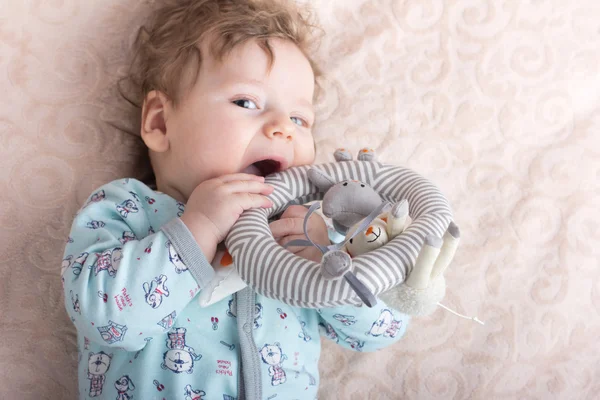 Beautiful baby with a lovely toys.The child in the crib