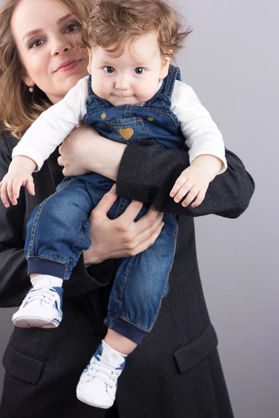 Young mother with a little boy in her arms. Portrait of mother and son. Beautiful blonde. pectoral baby. happy family