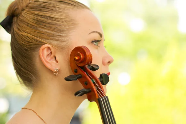 Girl playing on the violin outdoors. Musician for the wedding.Violin under the open sky