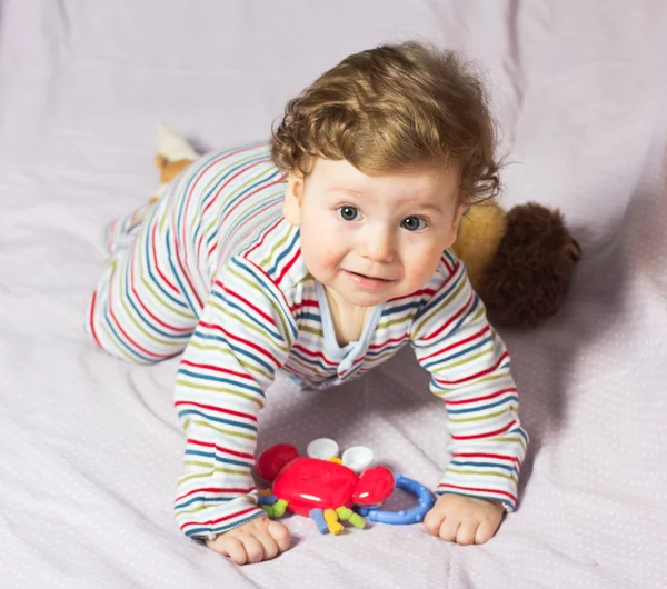 Beautiful baby with a lovely toy. The child in the crib.