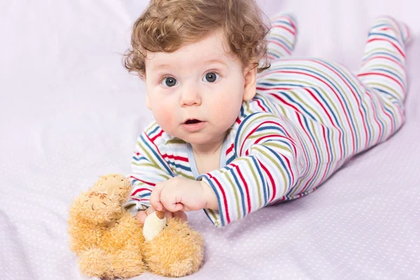 Beautiful baby with a lovely toy. The child in the crib.