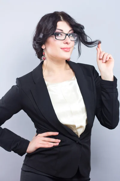 Business woman in a narrow black jacket. Successful woman. Beautiful brunette. Portrait of a beautiful girl in glasses