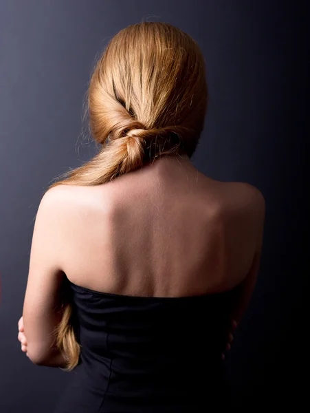 Beautiful female spin on a black background. Back pain. Cervical Spine. Beautiful Girl stands back.