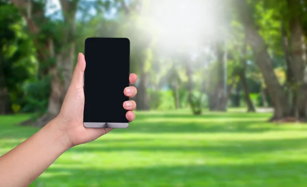 Hand hold smart phone with black  screens display on the garden