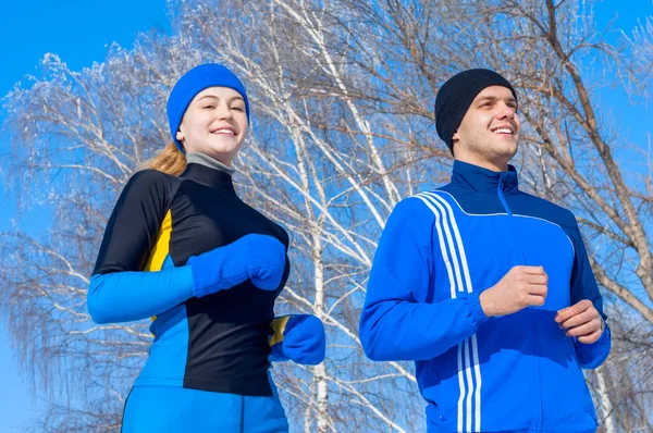 Runners. Young running couples. Sport man & woman jogging on winter rark