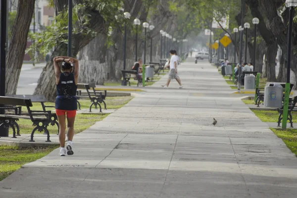 Woman does exercises in early morning on Avenida Arequipa in Lima, Peru.