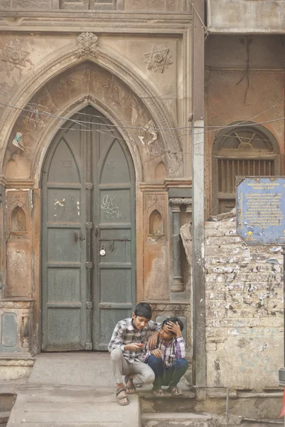 Indian boys sit on the steps of an old Primary school on Main Bazaar in Delhi, India.