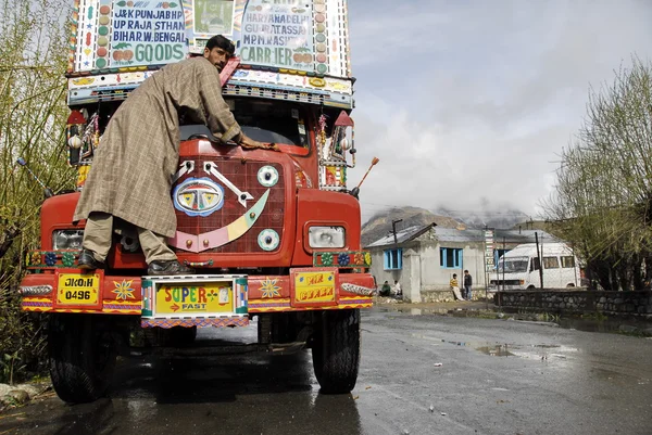 Indian driver washes his truck on a Srinagar - Leh road, India.