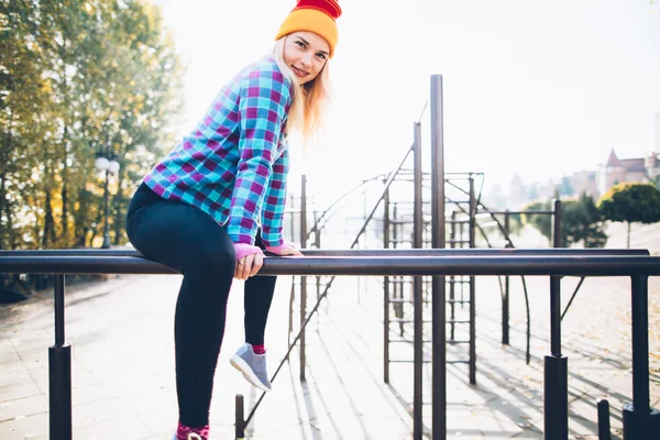 Young woman doing street workout at calisthenics park