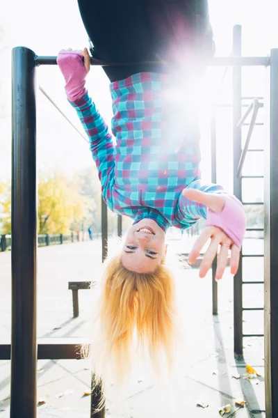 Young woman doing street workout at calisthenics park