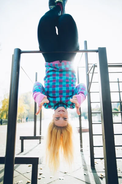 Young woman doing street workout at calisthenics park