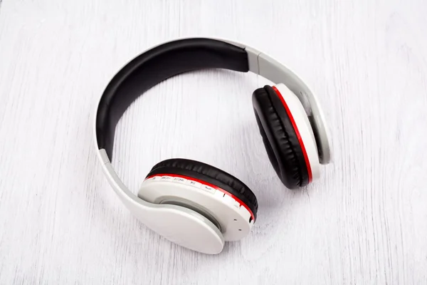 Bluetooth headphones on white wood background