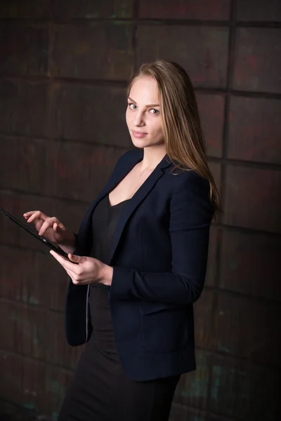 Young beautiful woman, business woman, lady, in a dark black suit,working on the tablet, work, using the tablet