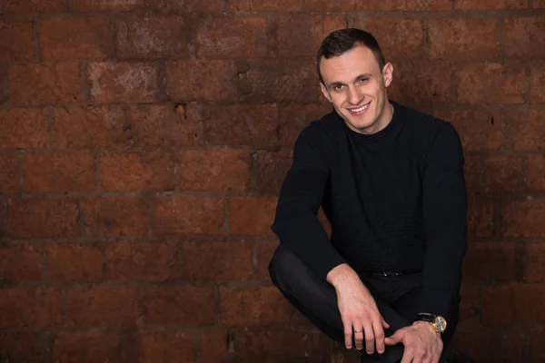 Wealthy man, dark background, short-haired man, businessma, a man in a dark  sweater, blazer, looking directly into the camera, stern look, business, brick wall, dark background, red brick, bright smile,