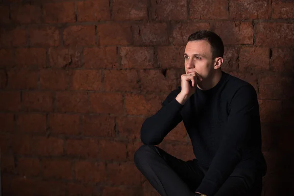 Wealthy man, dark background, short-haired man, businessma, a man in a dark  sweater, blazer, looking directly into the camera, stern look, business, brick wall, dark background, red brick, bright smile,