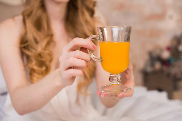 Woman\'s hands holding a transparent glass with orange juice, orange juice, bright, day, sunny,