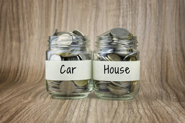 Two glass jars with coins labeled Car and House. Financial Conceptual