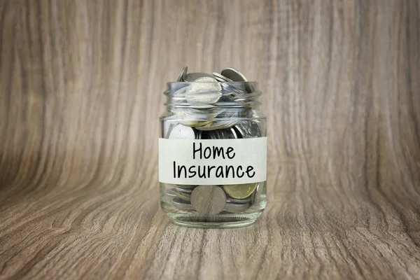 Glass jars with coins labeled Home Insurance. Financial Conceptual