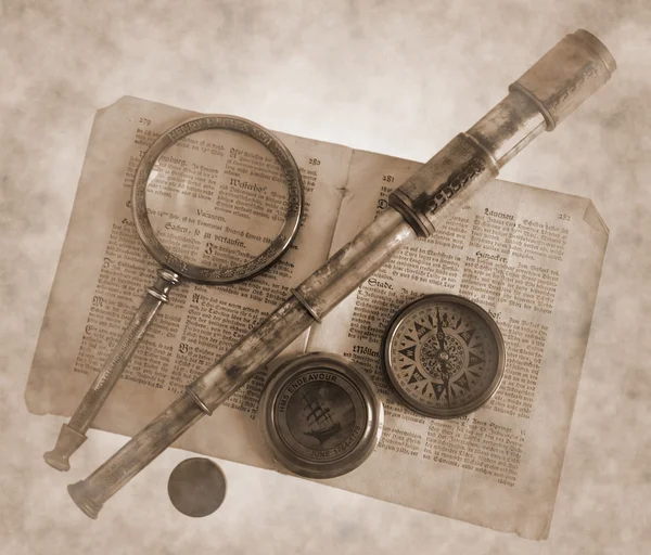Vintage telescope, magnifying glass, compass and paper